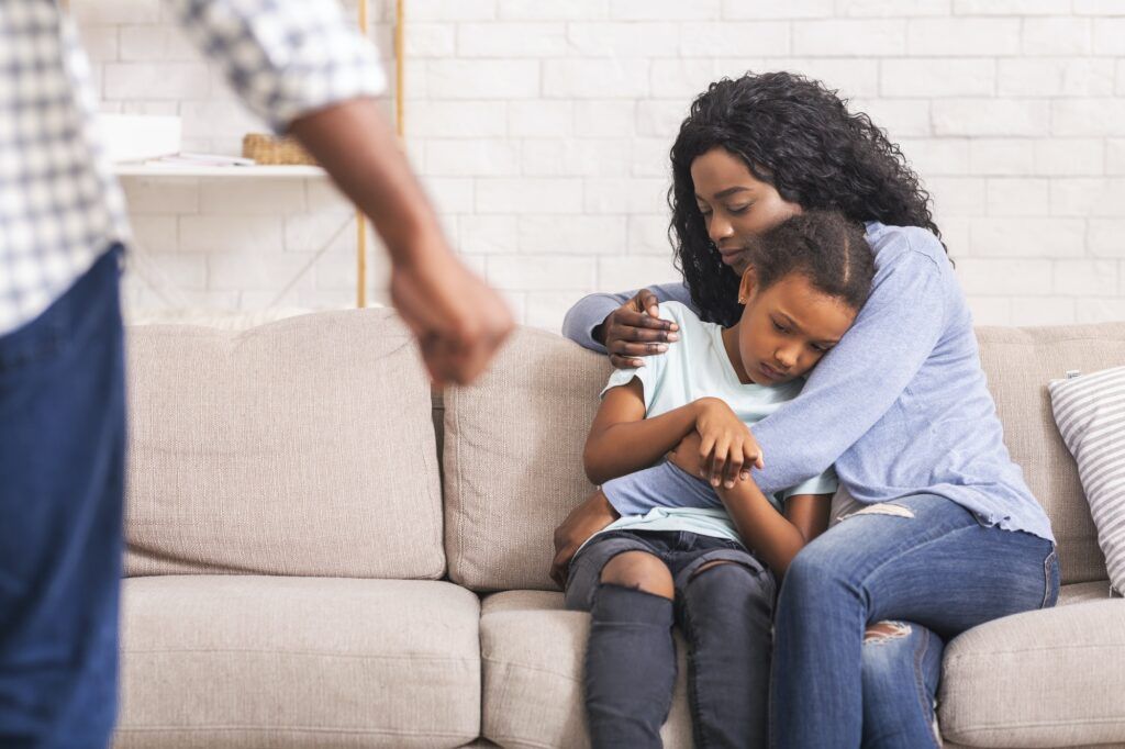 Afro mother and daughter suffering from domestic violence of father